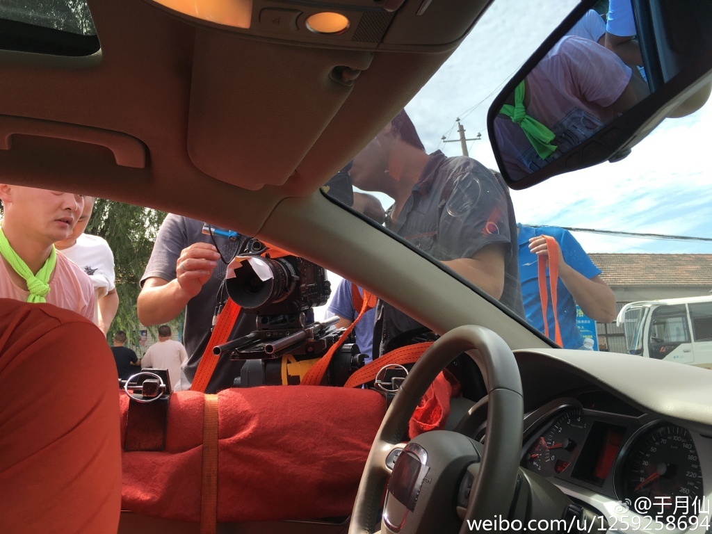 工作人员在忙碌地调试着机器,可以看出这是一场在车里的戏。