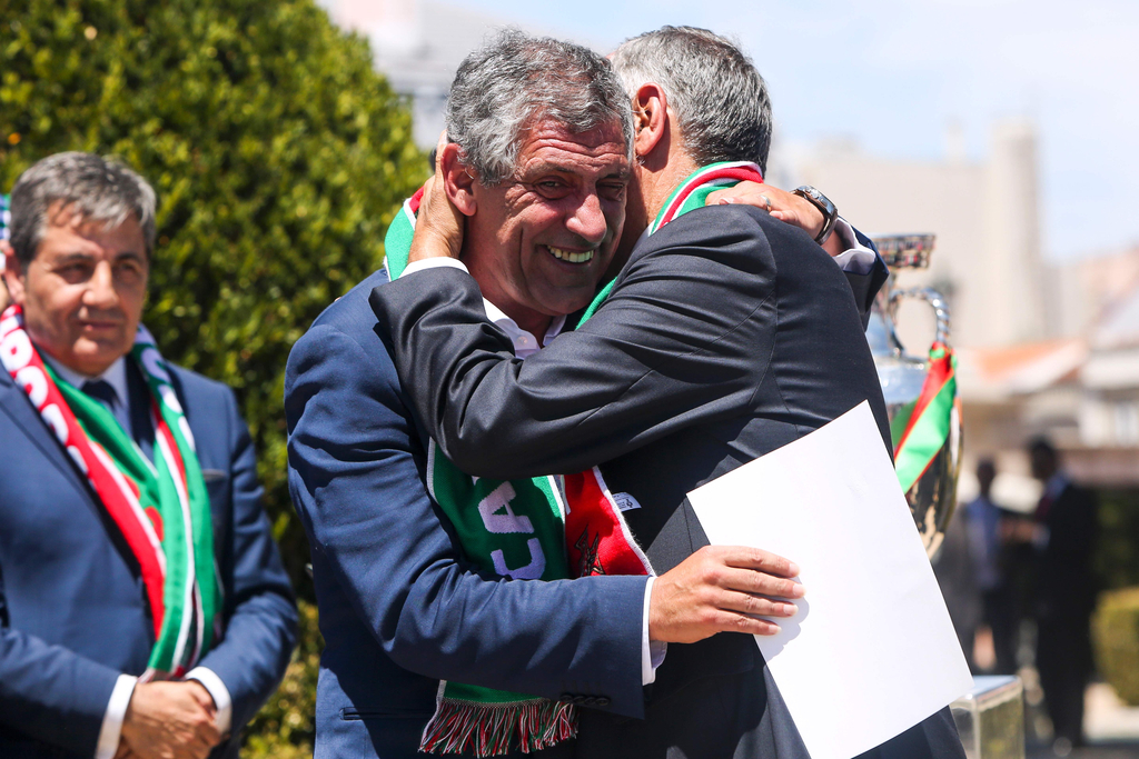 2016年7月11日，葡萄牙里斯本，2016年欧洲杯冠军葡萄牙队回到国内，全体队员和教练乘坐大巴游行并受到葡萄牙总统的接见，全城民众欢欣舞动狂欢庆祝。图为葡萄牙总统与主帅拥抱