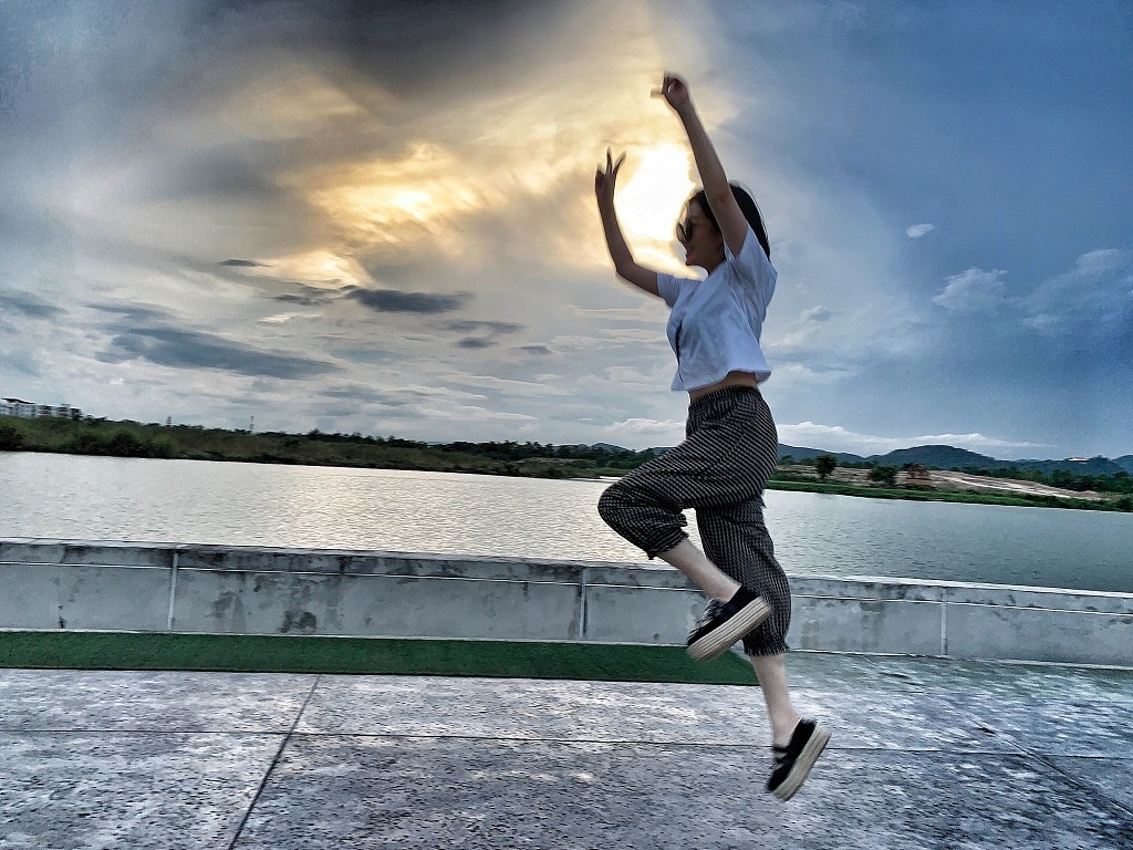 中许晴身穿白色t恤和八分裤,造型十分随性,在湖边的空地上欢欣雀跃,与