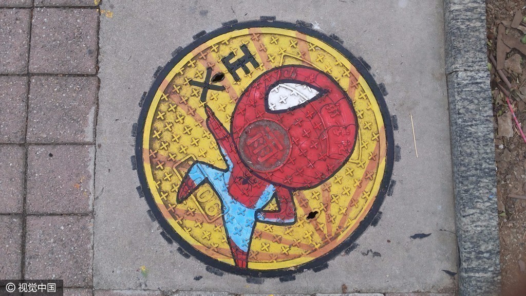 图为大学生在校园内井盖上画的美国队长涂鸦.