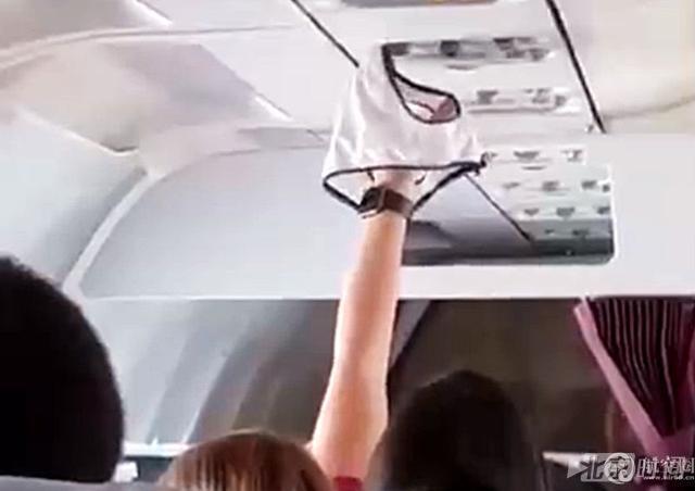 女子乘飞机高举“白色湿内裤” 对着空调口吹干