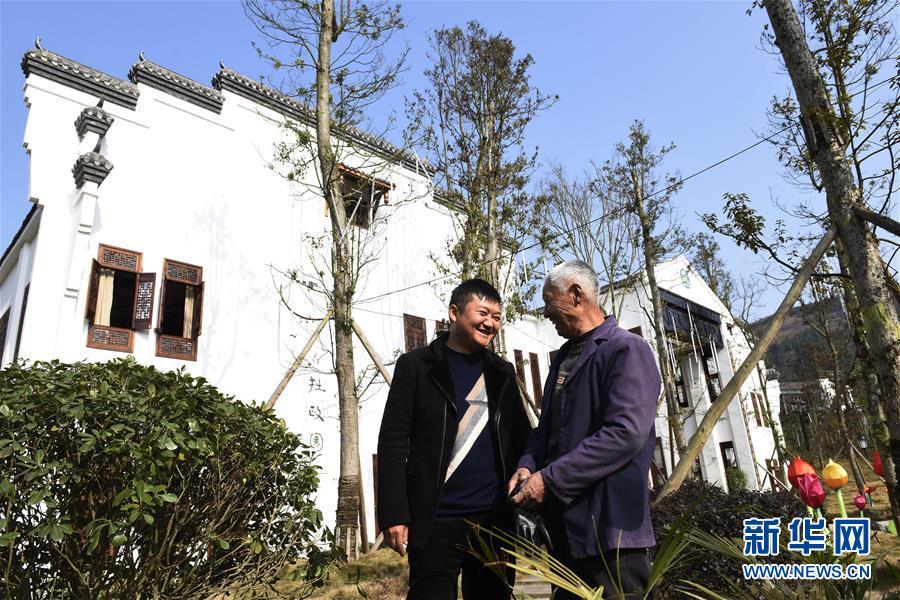 渠县万寿乡灵感村“第一书记”、退伍军人廖阳(左)在询问一名实现就近务工的村中贫困户的工作情况(2月8日摄)。新华社记者刘坤摄