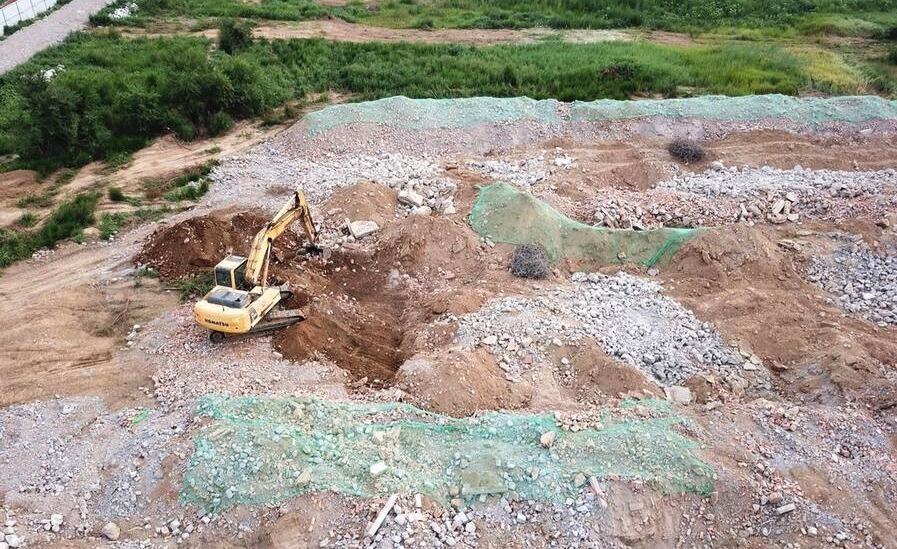 图为拆除后的烂尾别墅群，挖掘机在进行最后的作业。