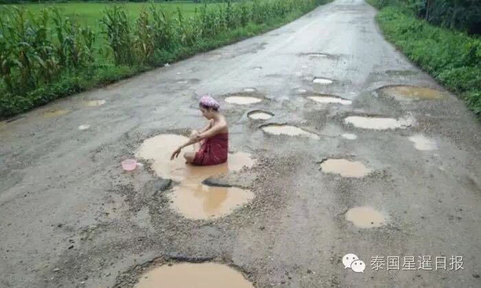 为了引起路管部门重视 女子在路坑积水中洗澡 为了引起路管部门重视 女子在路坑积水中洗澡