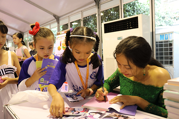 图为作家郁雨君为新华小记者签名