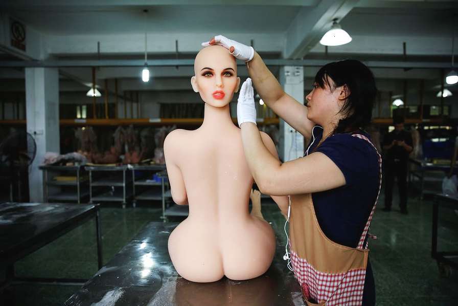广东中山，WMDoll公司生产车间内，工人正在组装一个充气娃娃。这家中国最大的充气娃娃生产厂商最近推出了一款名为“AI娃娃”的智能充气娃娃，她可以与“主人”进行简单的对话并转动胳膊和眼珠。