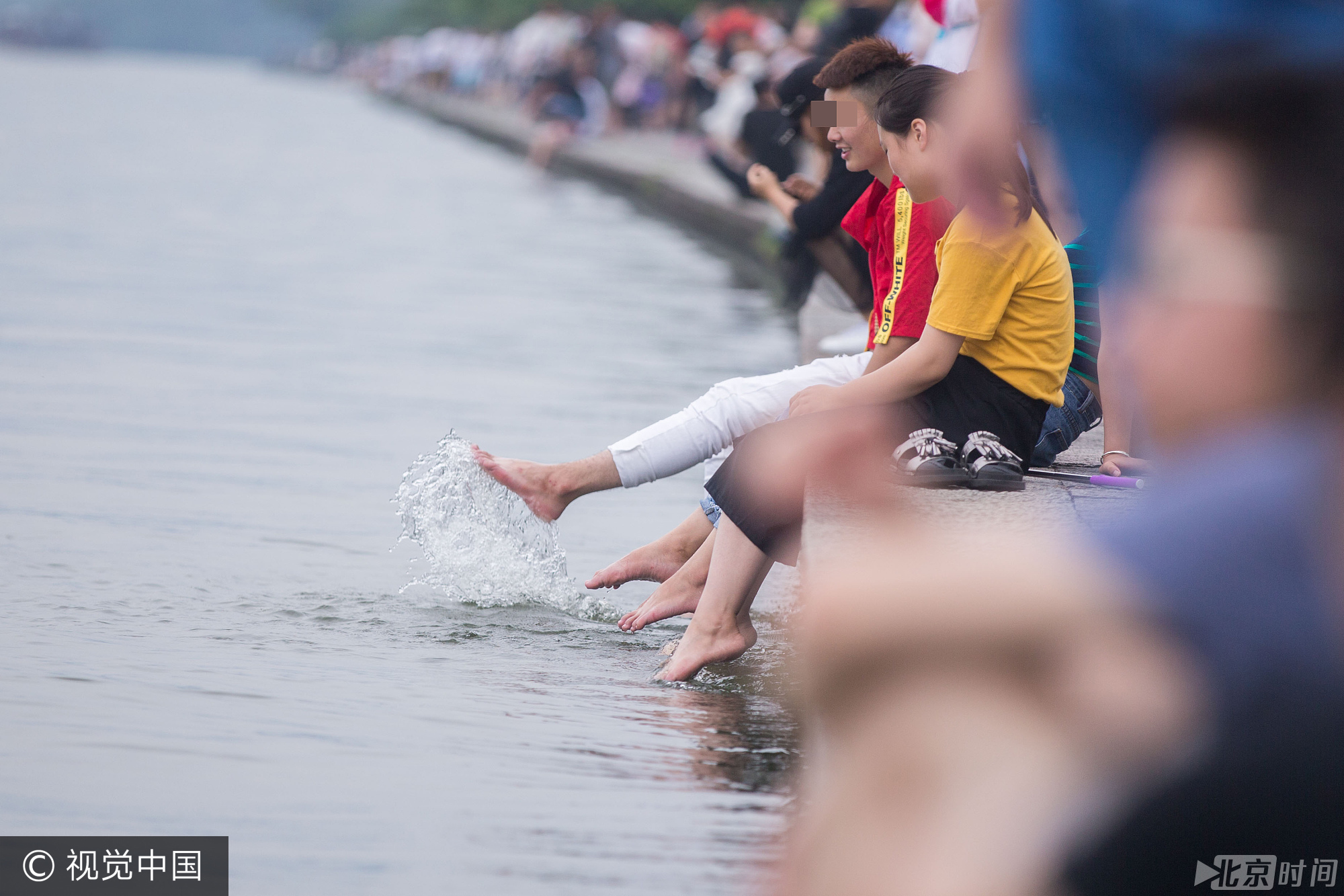 当日是周末，西湖景区游客很多。远远就能看到，一些游客坐在湖边，将脚伸进湖水里，享受片刻的清凉。