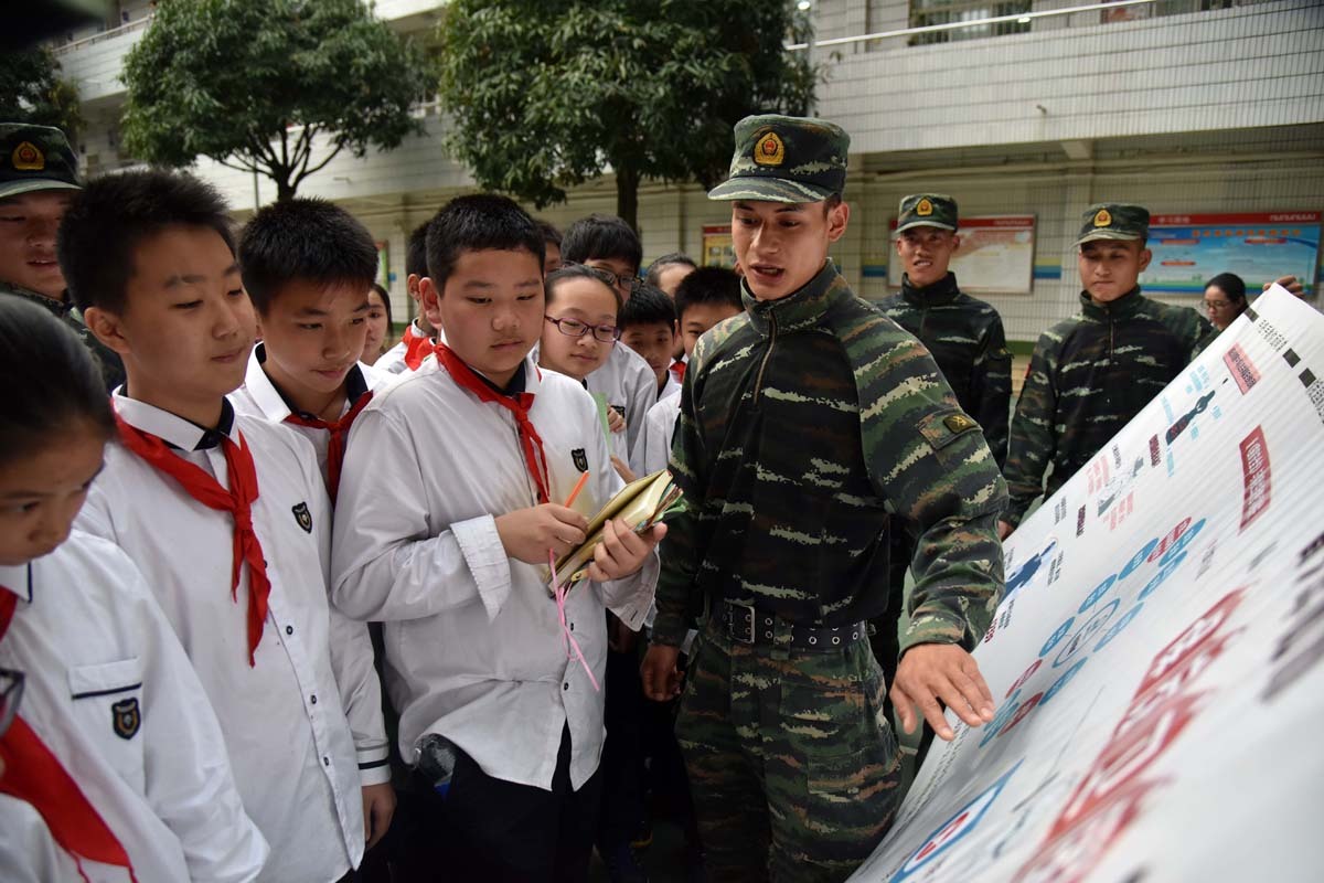 4月13日,武警广西总队南宁支队特战队员在向驻地师生进行爱国主义教育。王俞摄