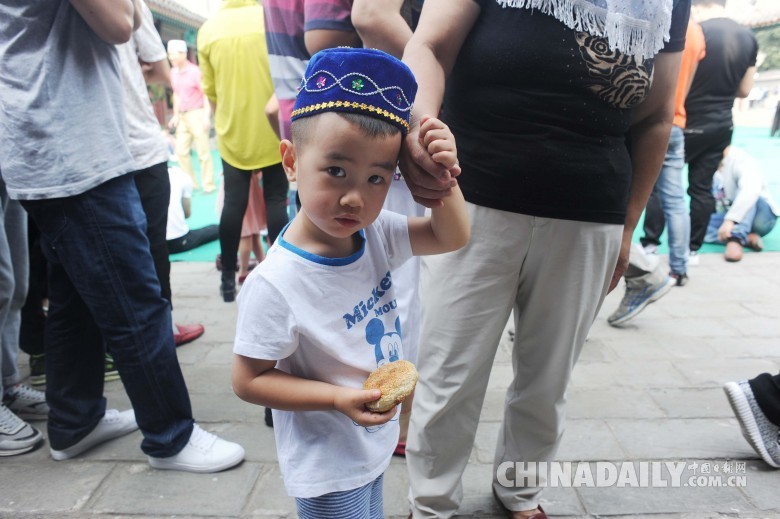 图为2016年7月6日，在北京牛街清真寺，一位小孩跟随家人参加会礼。