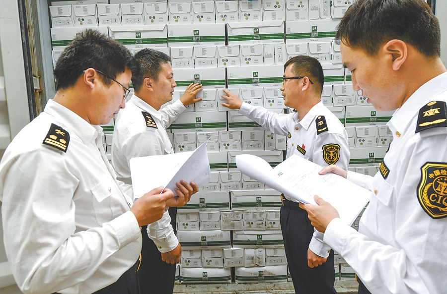 海关和出入境检验检疫人员在综合保税区对进口商品进行查验.