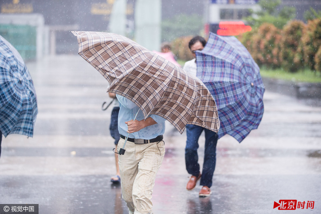 2016年10月21日，广东省深圳市，受今年第22号台风“海马”影响，深圳市区狂风暴雨，市民撑伞“艰难”前行。