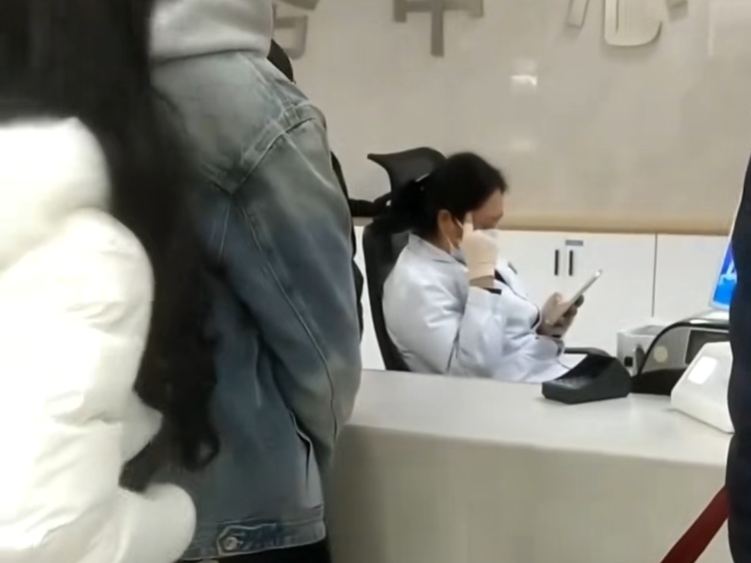 医院工作人员上班玩手机多人排队等缴费